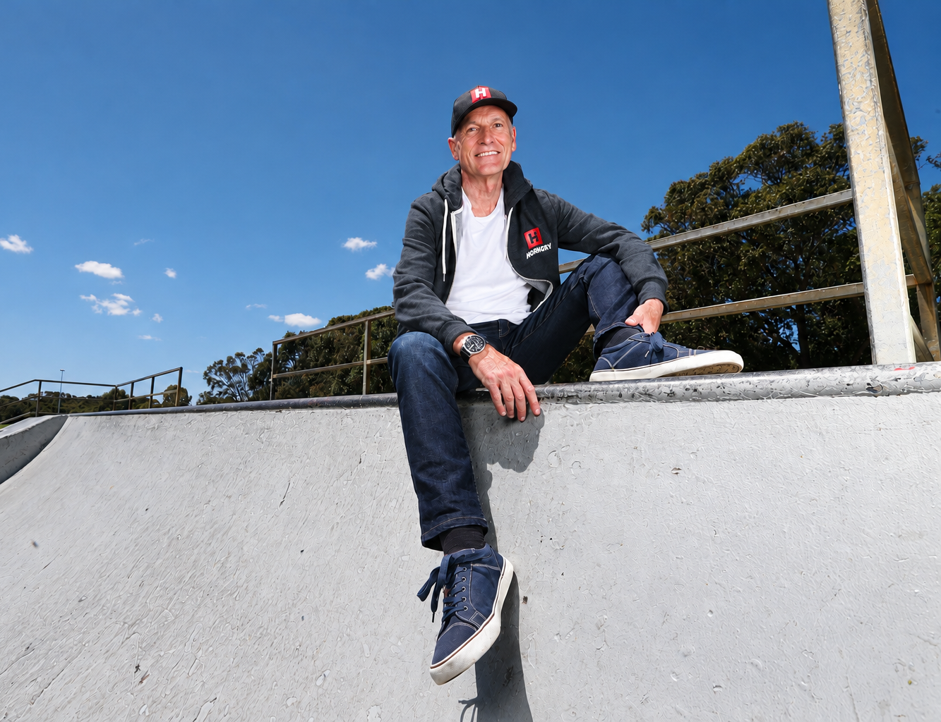 Brian Smithies, founder of HORNGRY, sitting on a skatepark ramp